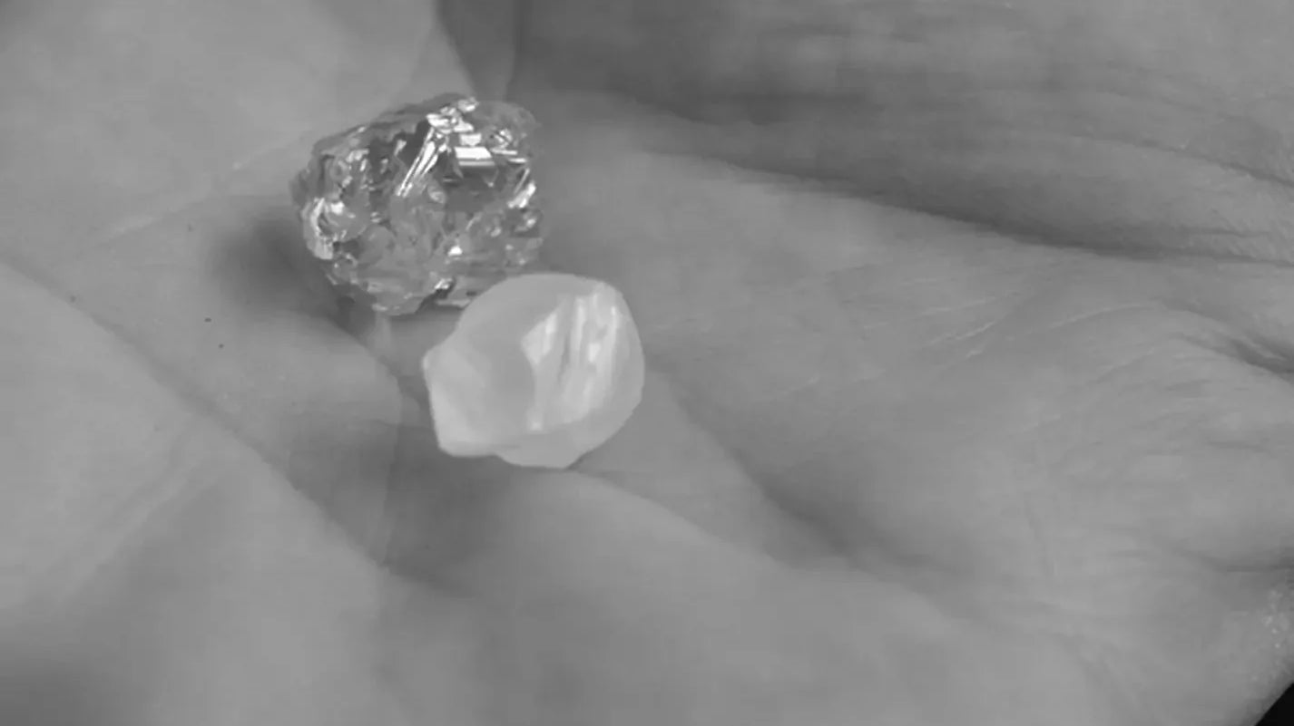 Two rough diamonds on a hand.