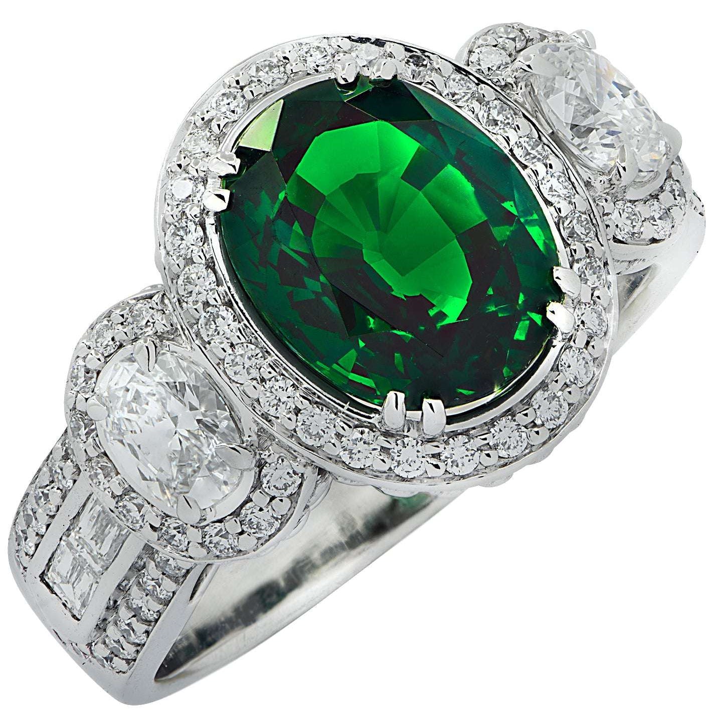 Vivid Diamonds 3.38Ct Oval Cut Tsavorite & Diamond Halo Ring in 18K White Gold featuring a vibrant green Tsavorite centerpiece surrounded by sparkling diamonds, exuding luxury.