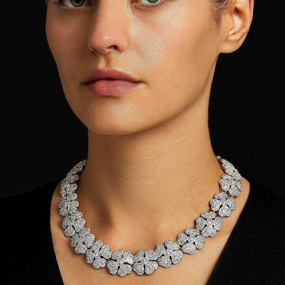 Sophisticated model displaying the Cartier Pave Diamond Clover Necklace from Vivid Diamonds, adorned with luminous diamond clovers in exquisite 18k white gold.