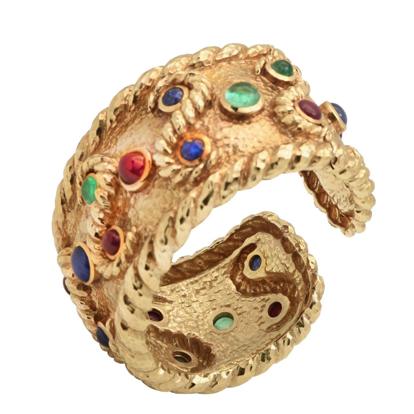 David Webb 18K Yellow Gold Cuff Bangle Bracelet featuring 6 Emeralds, 8 Rubies, and 6 Sapphires, elegantly crafted with a unique hammered texture, showcasing vibrant cabochon gemstones by Vivid Diamonds.