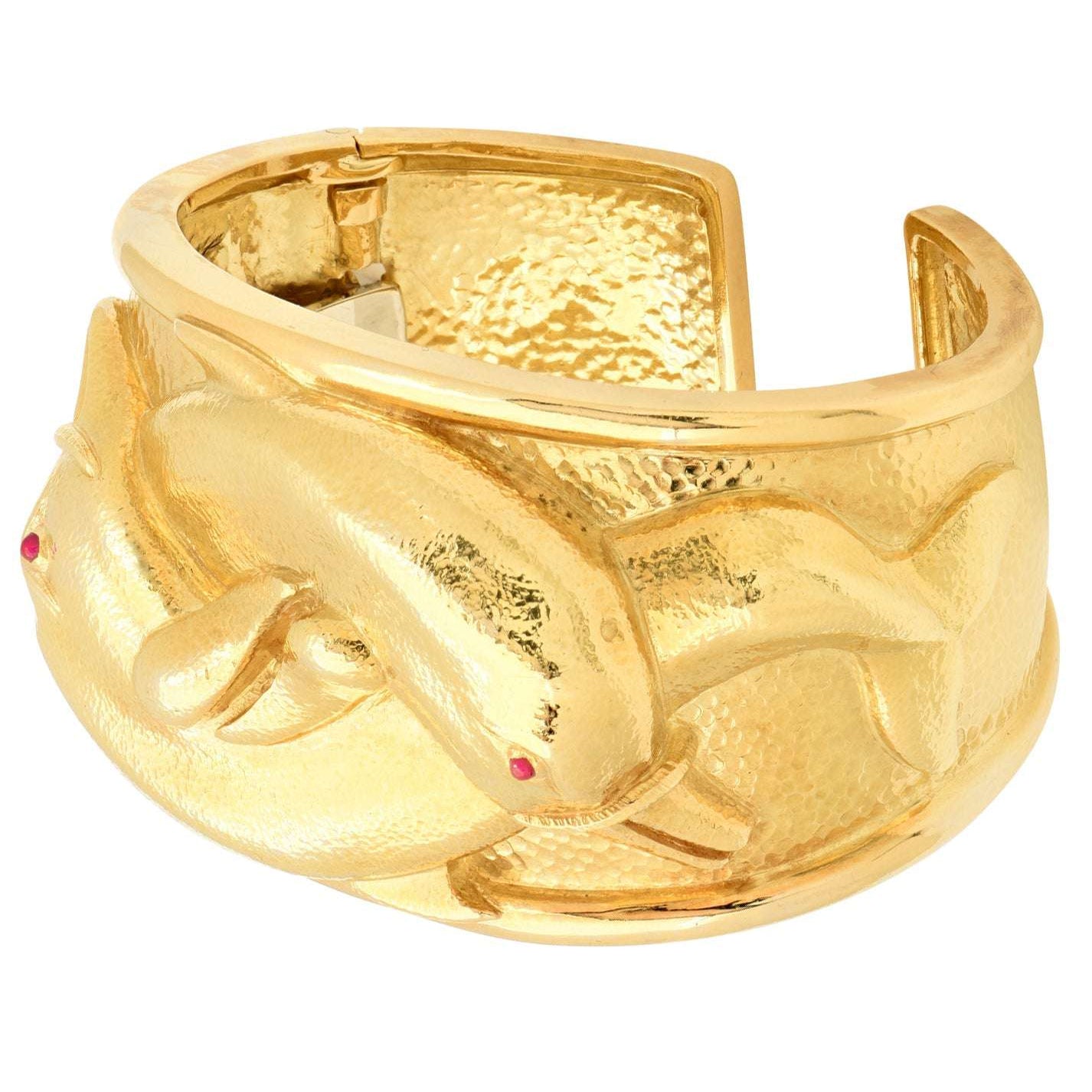 Side view of the David Webb 18K Yellow Gold Dolphin Cuff Bangle, showcasing its exquisite dolphin motifs and vibrant ruby accents, offered by Vivid Diamonds.