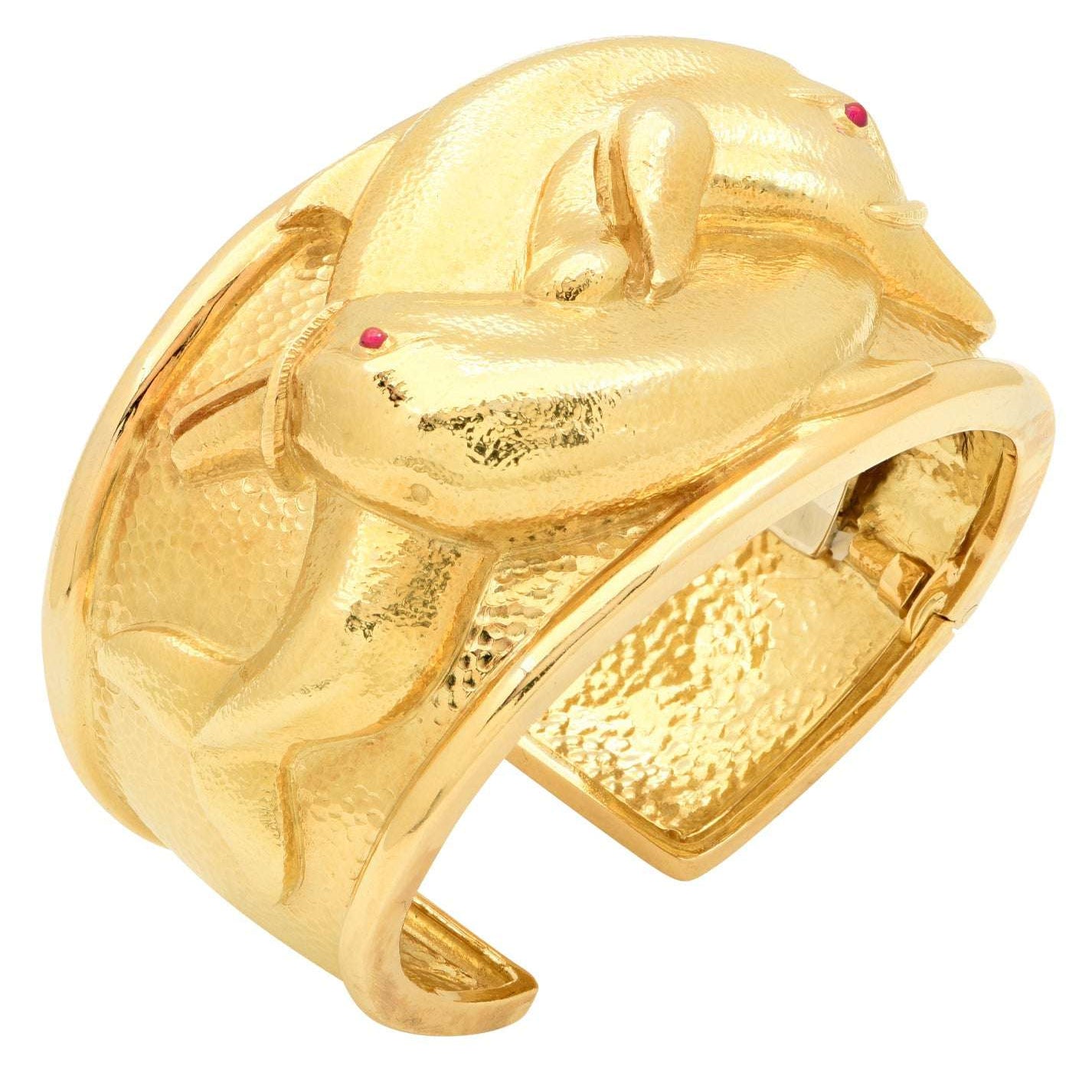 David Webb 18K Yellow Gold Dolphin Cuff Bangle featuring intricately designed dolphins and ruby accents, crafted by Vivid Diamonds, embodying luxury and elegance.