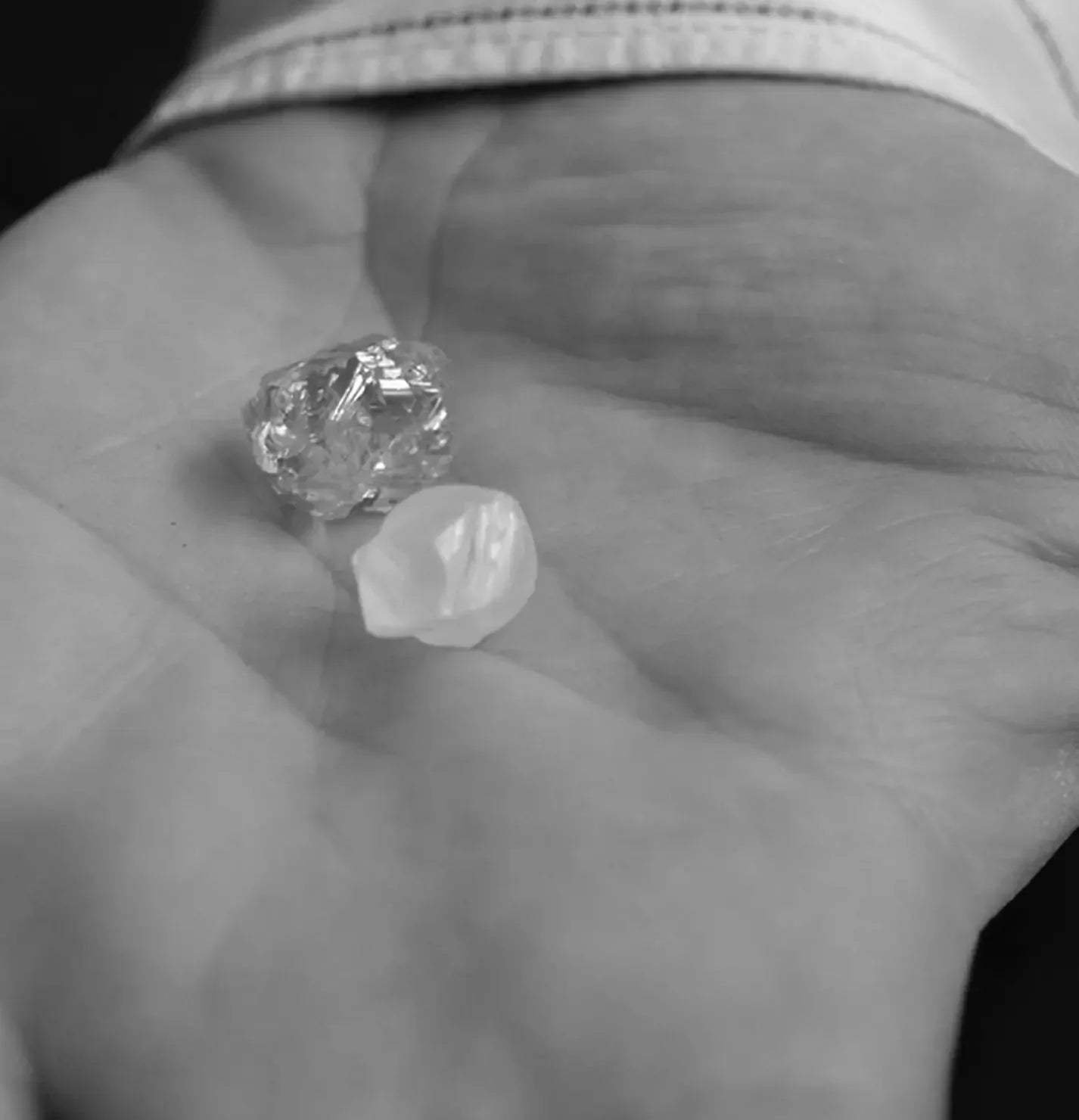 Two rough diamonds on a hand.