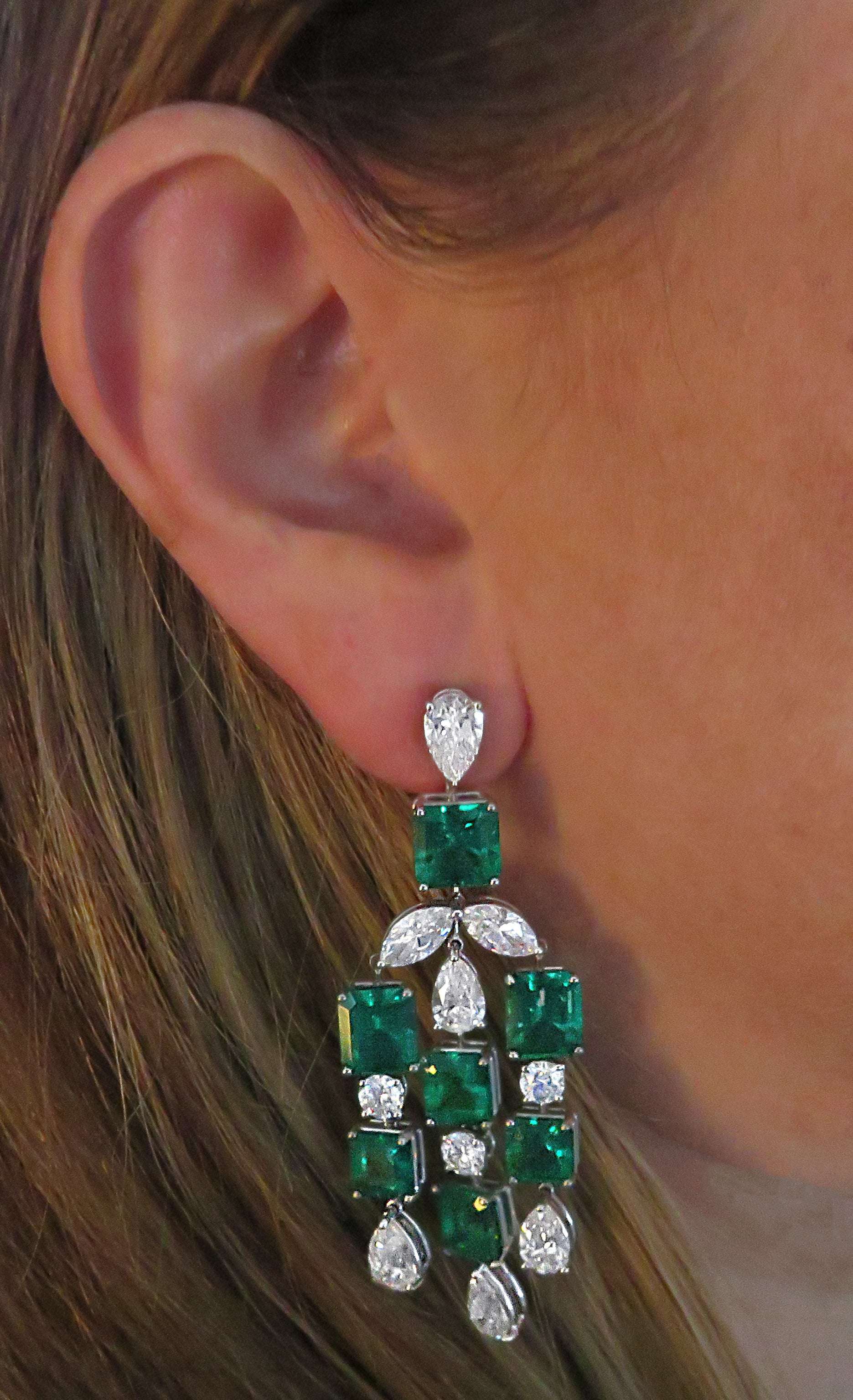 Elegant display of VIVID 24Ct Colombian Emerald & Diamond Dangle Earrings in Platinum worn, highlighting the vibrant Imperial Green emeralds and dazzling diamonds, perfect for luxury occasions.