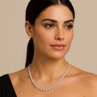 Model wearing diamond necklace V48490 by Vivid Diamonds, exuding sophistication and elegance, perfectly complementing her neckline.