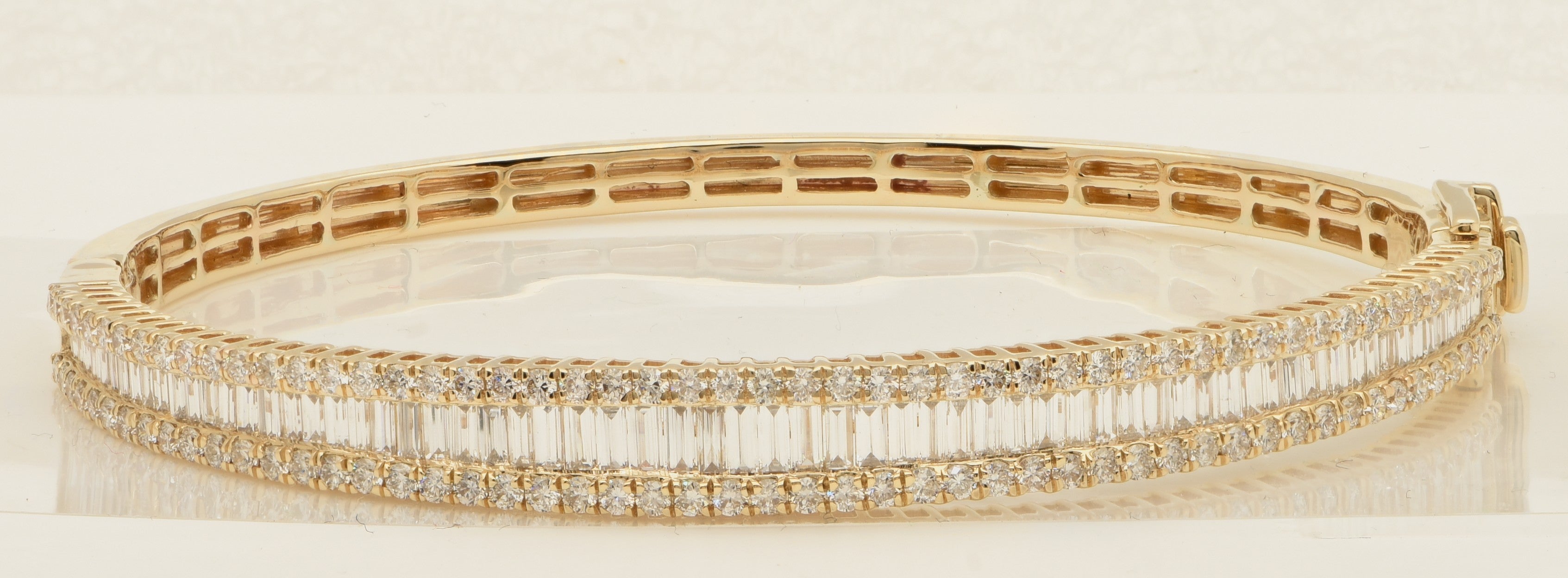 Elegant 14K Yellow Gold Diamond Bangle Bracelet by Vivid Diamonds, showcasing a breathtaking arrangement of round brilliant and baguette diamonds in a sophisticated triple-row design, embodying luxury and brilliance.