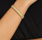 Elegant hand wearing the Exquisite 293-Diamond 18K Yellow Gold Bracelet by Vivid Diamonds, highlighting its stylish design and luxurious shine.