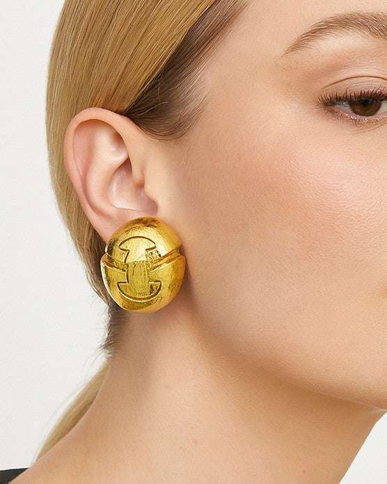 David Webb Earrings - Textured 18K Yellow Gold Button Design showcased elegantly on a model's ear, exuding timeless elegance by Vivid Diamonds.
